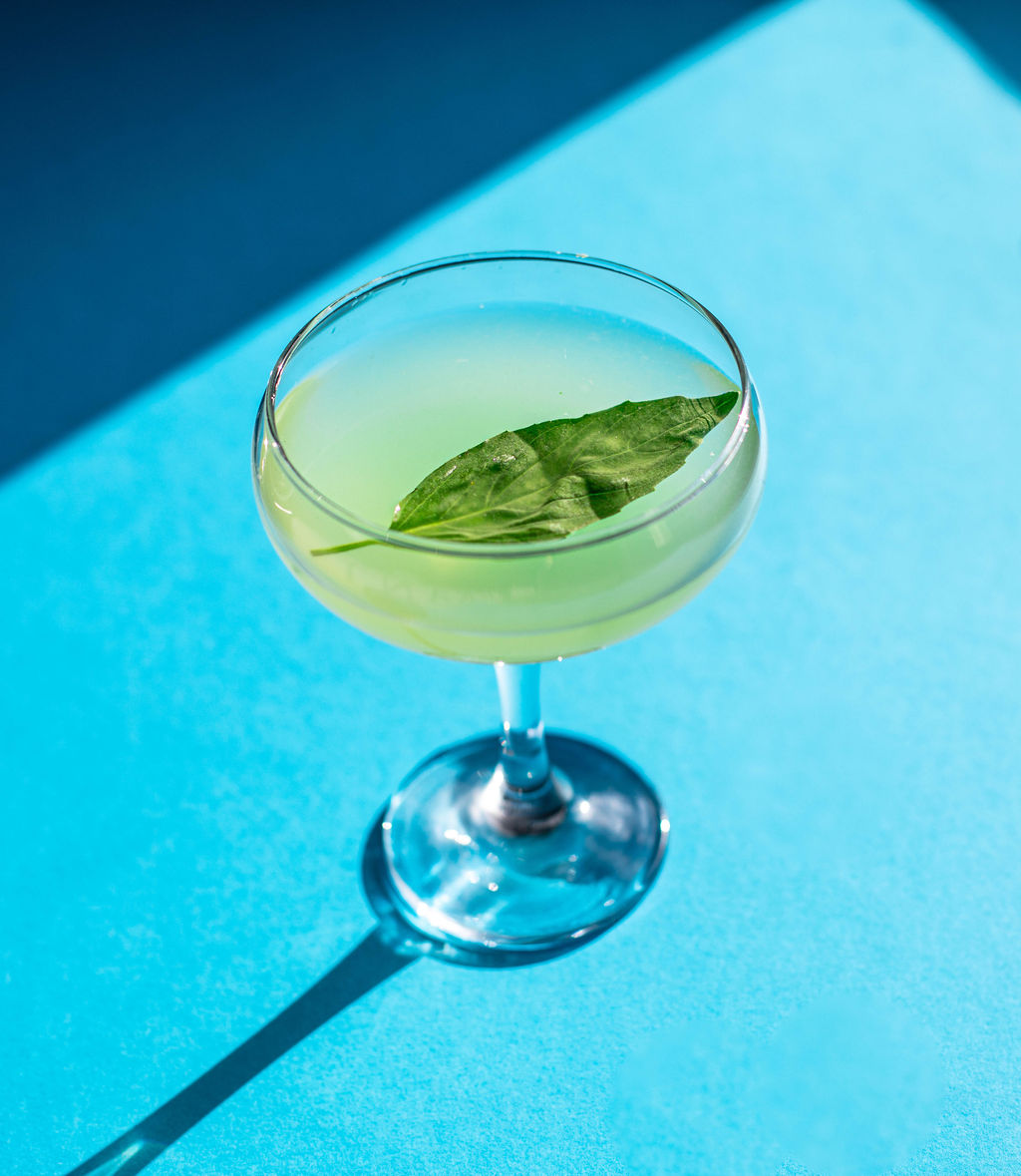 A cocktail on a blue studio backdrop