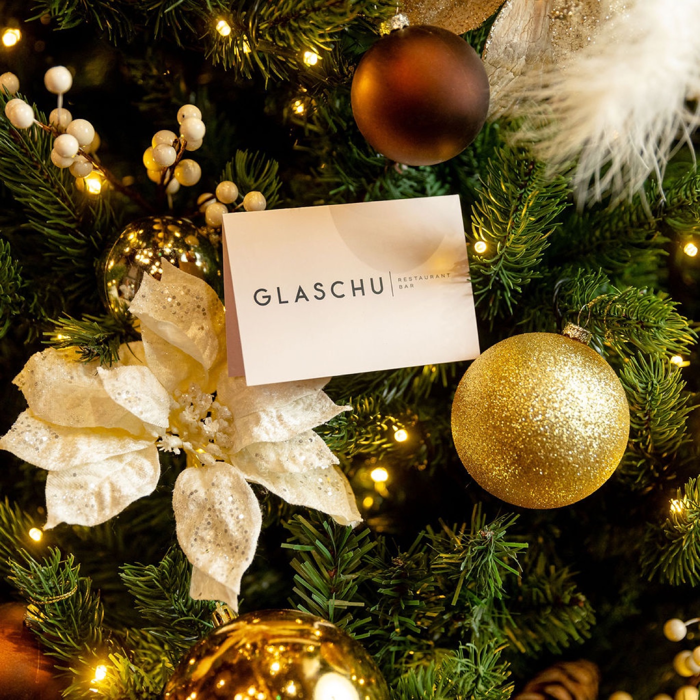 A Glaschu gift card tucked among gold baubles on the Christmas tree