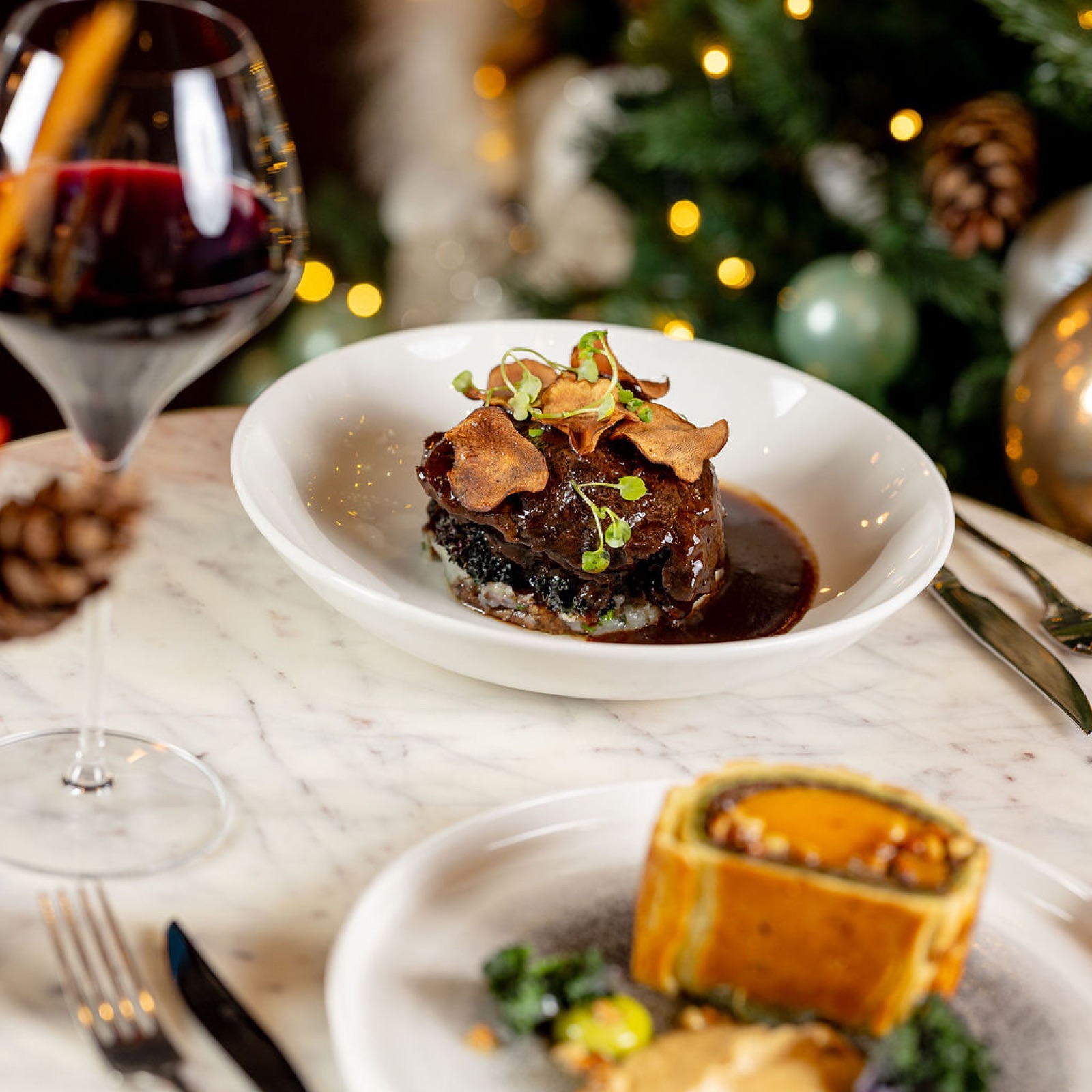 Squash, lentil and almond pithivier beside a glass of red wine