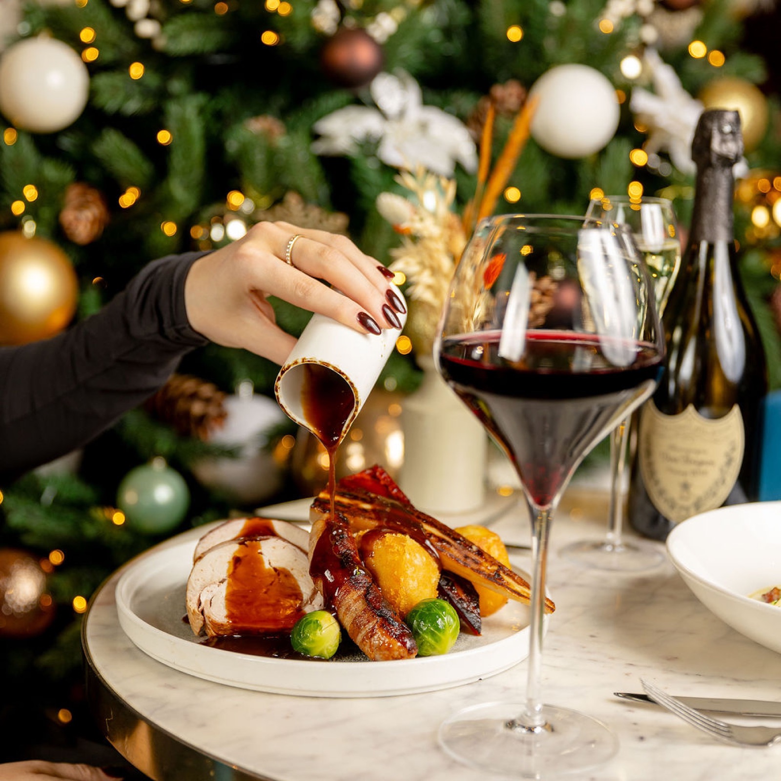 Red wine gravy poured over roast turkey at the table