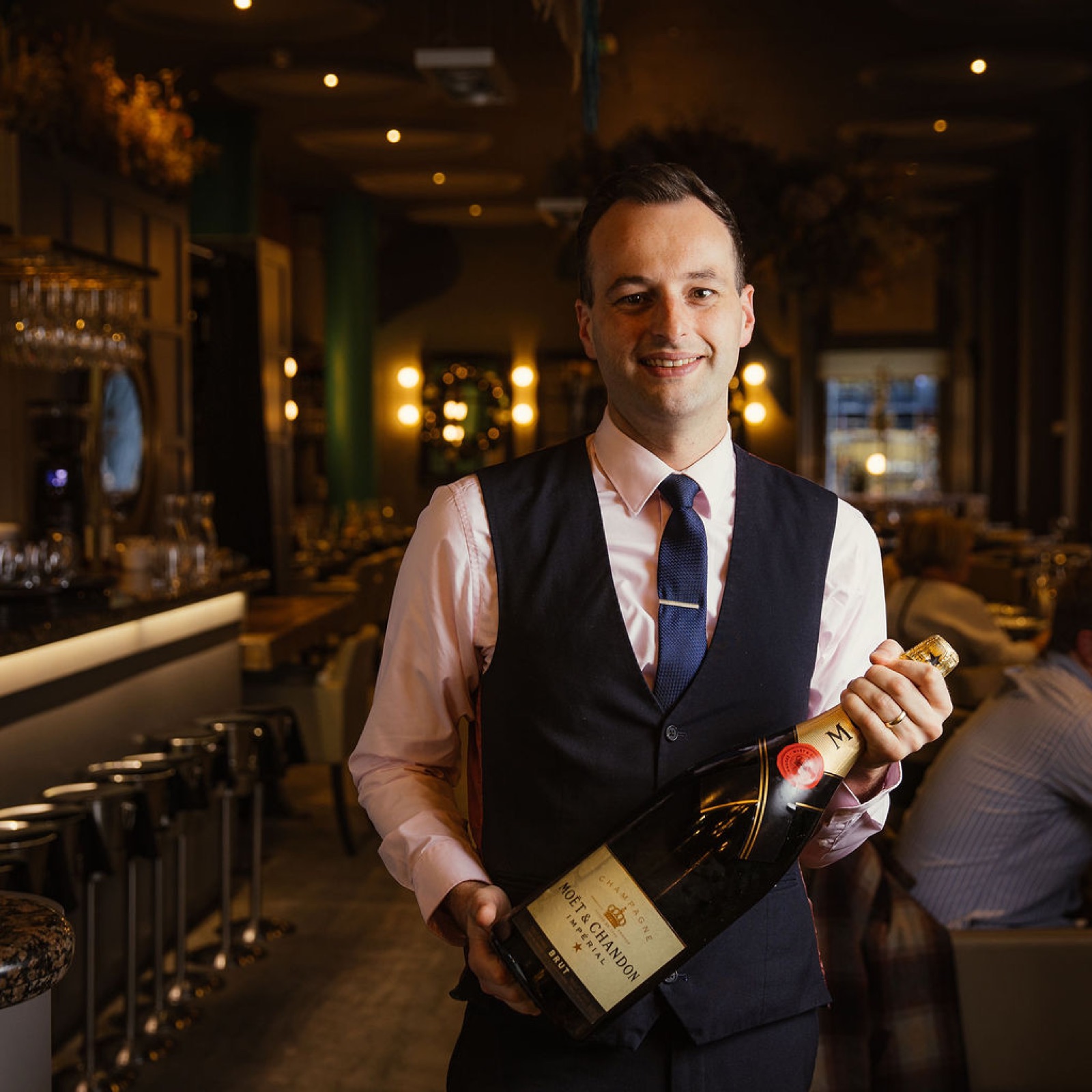 A member of the Glaschu team carrying a magnum of champagne