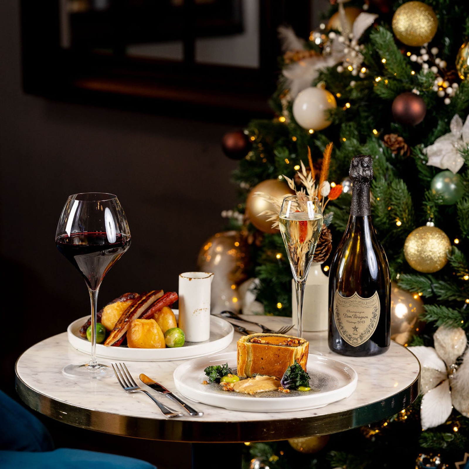 Roast turkey with the trimmings and a bottle of champagne by the tree