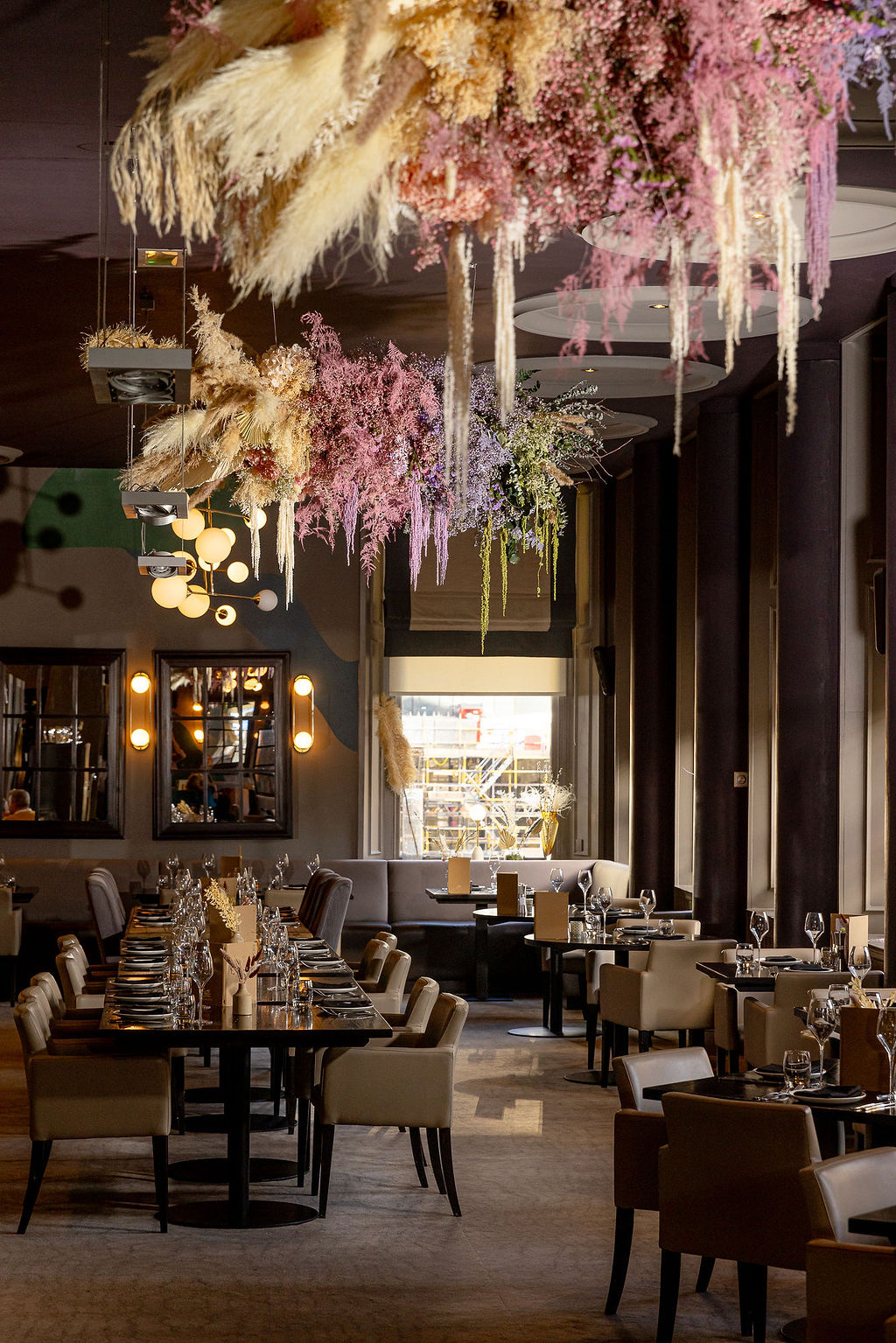 The Glaschu dining room set for service beneath its dried-flower installation