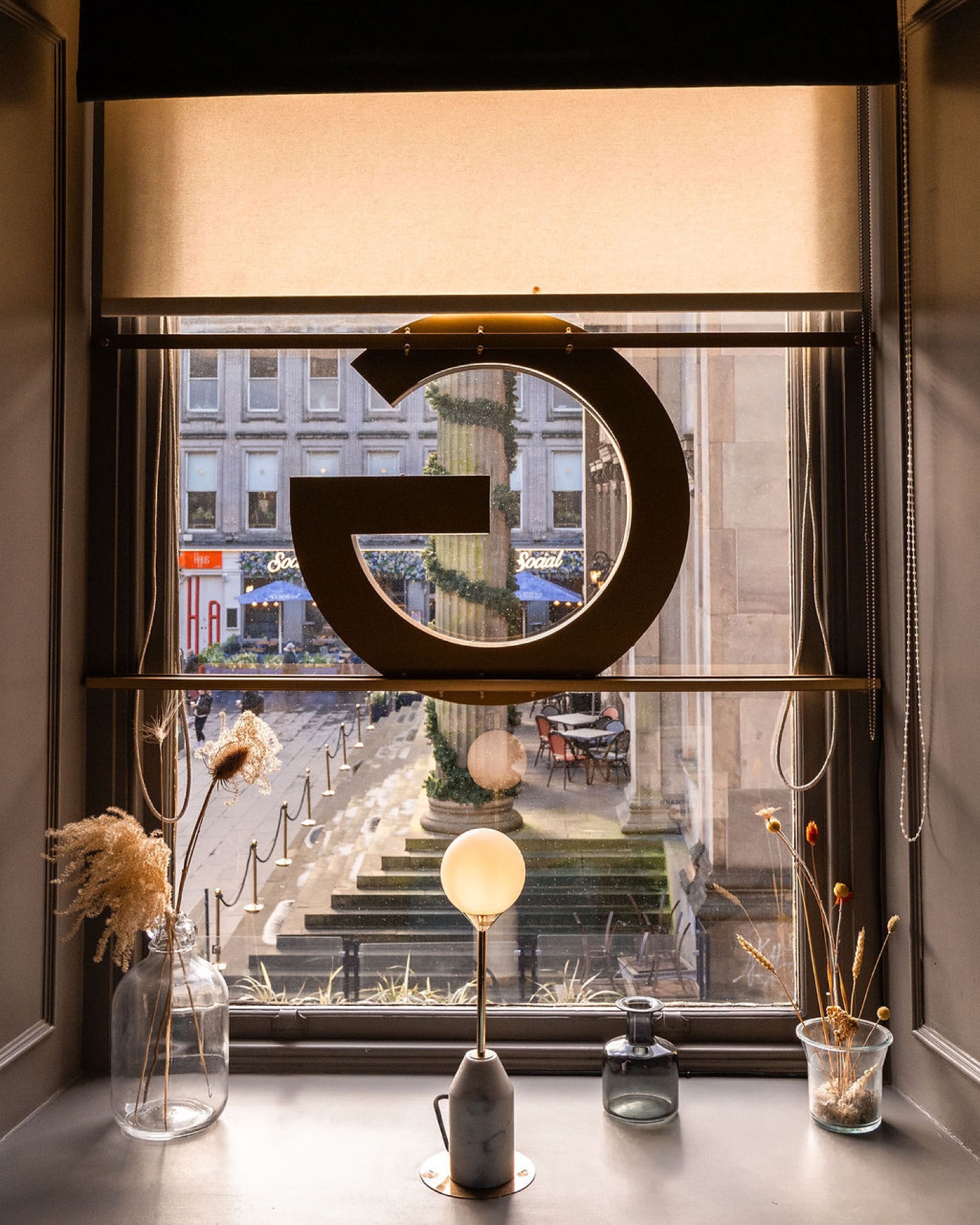 The gold Glaschu monogram in a first-floor window over Royal Exchange Square