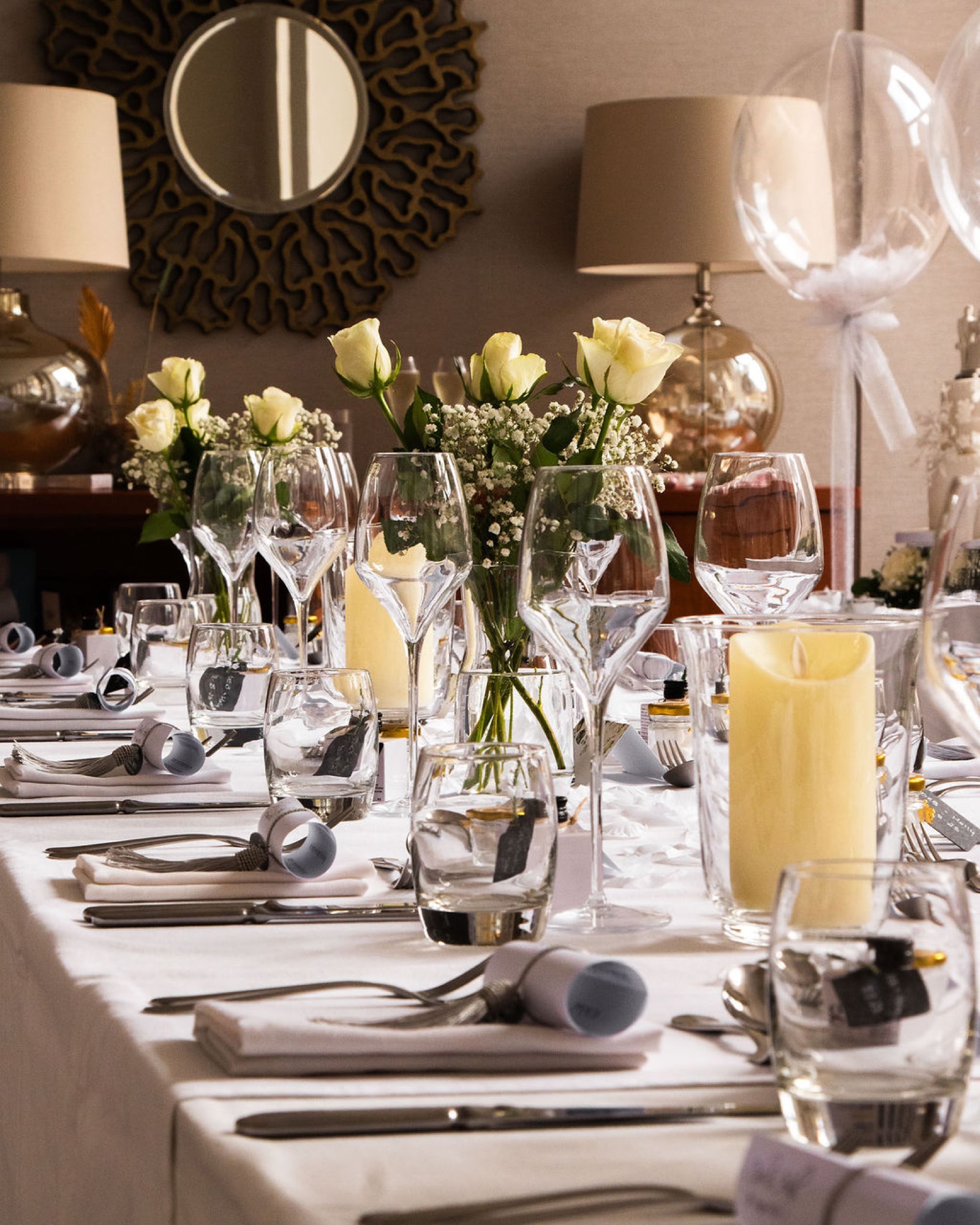 A wedding dinner table at Glaschu dressed with white roses and candlelight